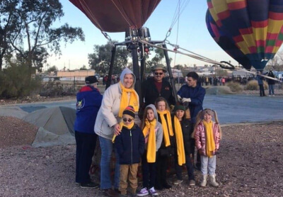 parents assisting children view hot-air balloons